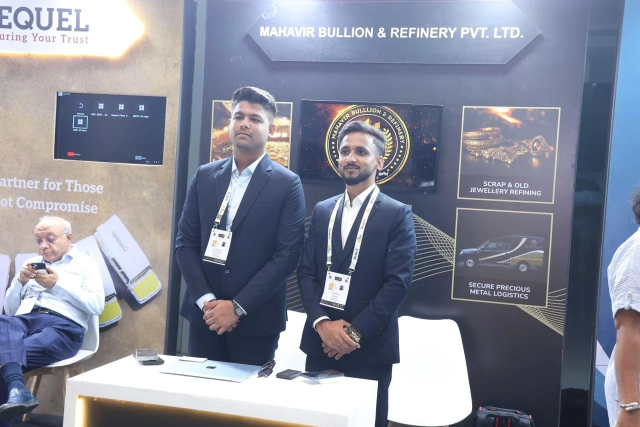 Two attendees standing at the Mahavir booth at IIBS