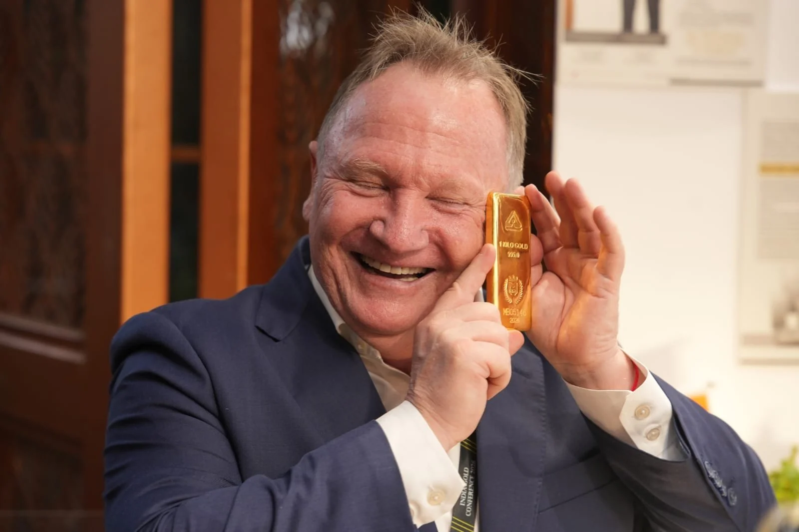 Conference attendee holding a gold bar, as published by Mahavir